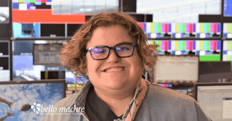 Bello Machre youth wearing earbuds smiling