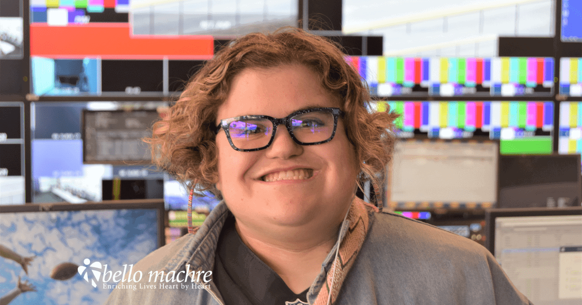 Bello Machre youth wearing earbuds smiling