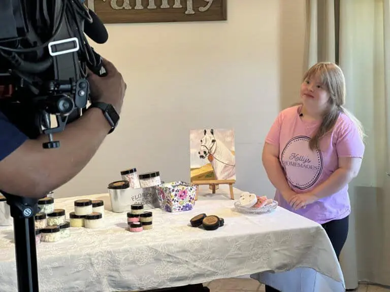 Kelly standing next to her handmade products being interviewed for CBS Baltimore