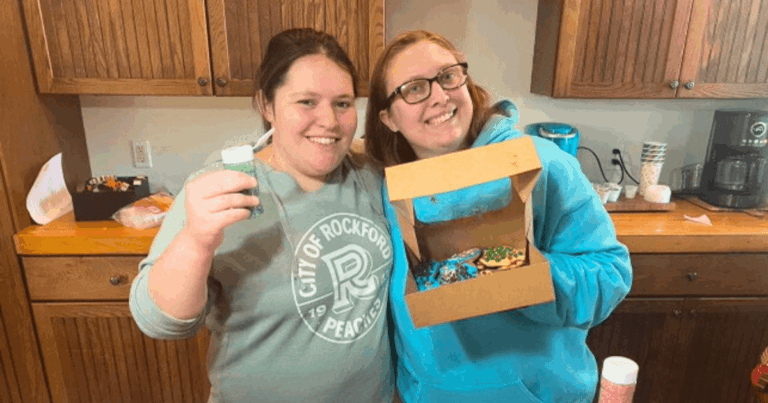 Hannah and friend showing off box of cookies