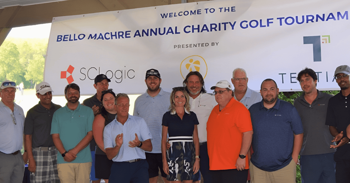 SCLogic team members in front of Golf Tournament banner